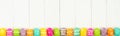 Colorful Easter banner with row border of Easter Eggs over a white wood background with copy space Royalty Free Stock Photo