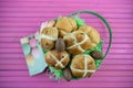 Chocolate Easter eggs and food in a gift basket with pink table background