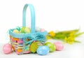 A colorful Easter basket full of sparkly eggs in blue, pink, yellow and green with copy space on a bright white background. Royalty Free Stock Photo