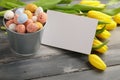 Colorful easter candy eggs with yellow tulips and empty greeting card Royalty Free Stock Photo