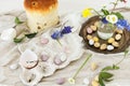 Colorful easter chocolate eggs, easter bread, spring flowers and linen cloth on rustic wooden table. Easter modern simple Royalty Free Stock Photo