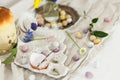 Colorful easter chocolate eggs, easter bread, spring flowers and linen cloth on rustic wooden table. Easter modern simple Royalty Free Stock Photo