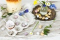 Colorful easter chocolate eggs, easter bread, spring flowers and linen cloth on rustic wooden table. Easter modern simple Royalty Free Stock Photo
