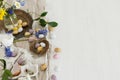 Colorful easter chocolate eggs in nest, spring flowers, feathers and linen cloth on rustic wooden table. Space for text. Easter Royalty Free Stock Photo
