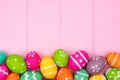 Colorful Easter egg bottom border against pink wood