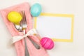 Colorful Easter Egg Table Setting with Silverware, Dyed eggs, Pink Napkin, Card on off white cloth