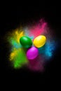Colorful Easter eggs on the background of a mixture of colors. Colorful powder on black background. Royalty Free Stock Photo