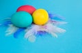 Colorful easter eggs in a basket on a blue color background with a copyspace