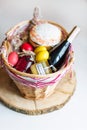 Colorful easter eggs in a basket with cake, red wine, hamon or jerky and dry smoked sausage on white background. Royalty Free Stock Photo