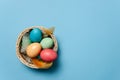 Colorful Easter eggs in a basket among feathers Royalty Free Stock Photo