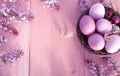 Colorful easter eggs in basket on wooden table.Holiday background with spring lilac flowers. Top view with copy space Royalty Free Stock Photo