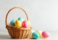 Colorful Easter Eggs in Basket with Straw on Neutral Background Royalty Free Stock Photo