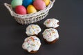 Colorful Easter eggs in basket and sweet muffins cupcakes on a black background. Easter background Royalty Free Stock Photo