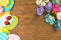 Colorful Easter eggs border, old rustic wood background with spring flowers, flat lay design, top view with copy space Royalty Free Stock Photo