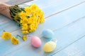 Colorful Easter eggs with bouquet of yellow chrysanthemum on blue wooden background. Royalty Free Stock Photo