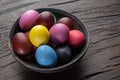Colorful Easter eggs in bowl on wooden table. Attribute of Easter celebration Royalty Free Stock Photo