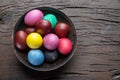 Colorful Easter eggs in bowl on wooden table. Attribute of Easter celebration Royalty Free Stock Photo