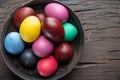 Colorful Easter eggs in bowl on wooden table. Attribute of Easter celebration Royalty Free Stock Photo