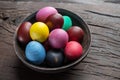 Colorful Easter eggs in bowl on wooden table. Attribute of Easter celebration Royalty Free Stock Photo