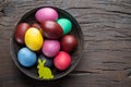 Colorful Easter eggs in bowl on wooden table. Attribute of Easter celebration Royalty Free Stock Photo