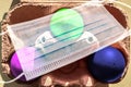 Colorful Easter Eggs in a box covered in corona masks during lockdown in Germany Royalty Free Stock Photo
