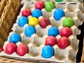Colorful easter eggs in carton trays with wicker baskets Royalty Free Stock Photo