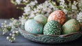 Colorful easter eggs displayed in a decorative tray surrounded by white floral blossoms Royalty Free Stock Photo