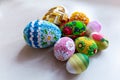 Colorful Easter eggs with floral ornaments, origami decorations and crewel wool against white background