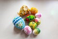 Colorful Easter eggs with floral ornaments, origami decorations and crewel wool against white background