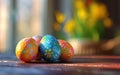 Colorful Easter eggs with floral patterns on a wooden surface, blurred spring flowers in the background. Royalty Free Stock Photo