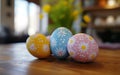 Colorful Easter eggs with floral patterns on a wooden surface, blurred spring flowers in the background. Royalty Free Stock Photo