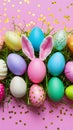 Colorful Easter eggs, golden confetti, pink background, festive bunny ears Royalty Free Stock Photo