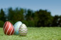 Colorful Easter eggs on green grass under a clear blue sky. Royalty Free Stock Photo