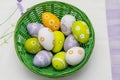 Colorful Easter eggs in a green wicker basket. View from above. Flatlay Royalty Free Stock Photo