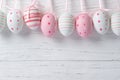 Colorful easter eggs hanging on a rope on a wooden background