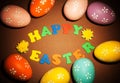Colorful Easter eggs, Happy Easter inscription and flowers on br Royalty Free Stock Photo