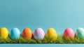 Colorful Easter Eggs Lined on Grass With Blue Wall Backdrop During Spring Season Royalty Free Stock Photo