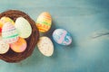 Colorful easter eggs in nest on blue wood background with copy s Royalty Free Stock Photo