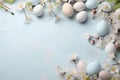 Colorful Easter eggs and spring white flowers on blue background, flat lay composition with copy space for text Royalty Free Stock Photo