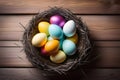 Colorful Easter eggs in a straw nest on a wooden background. Top view Royalty Free Stock Photo