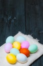 Colorful Easter eggs on towel on old rustic wooden background