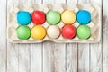Colorful easter eggs in a tray over wooden background. Space for text. Easter card. Royalty Free Stock Photo