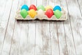 Colorful easter eggs in a tray over wooden background. Space for text. Easter card. Royalty Free Stock Photo