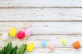 Colorful Easter eggs with tulip flower on rustic wooden planks background. Royalty Free Stock Photo