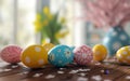 Colorful Easter eggs with various patterns on a wooden table, with spring flowers in the background. Royalty Free Stock Photo