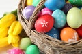 Colorful Easter eggs in wicker basket on table, closeup Royalty Free Stock Photo