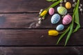 Colorful Easter eggs with yellow Tulip hand painted on a dark wooden background. Holiday spring card Royalty Free Stock Photo