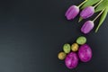 Colorful easter and quail eggs and tulip flowers on stone table. Top view with copy space Royalty Free Stock Photo