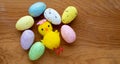 Colorful Easter toy eggs and a yellow toy chicken on a wooden background.The Concept Of Easter. Space for your text Royalty Free Stock Photo