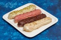 Colorful eclair cakes with cream on blue background Royalty Free Stock Photo
